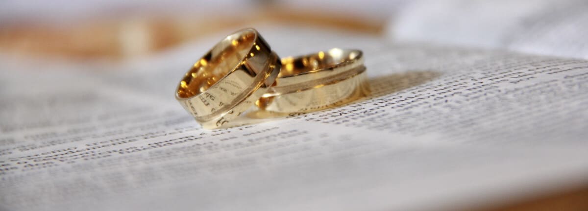 rings from another under an open book symbolize union, marriage