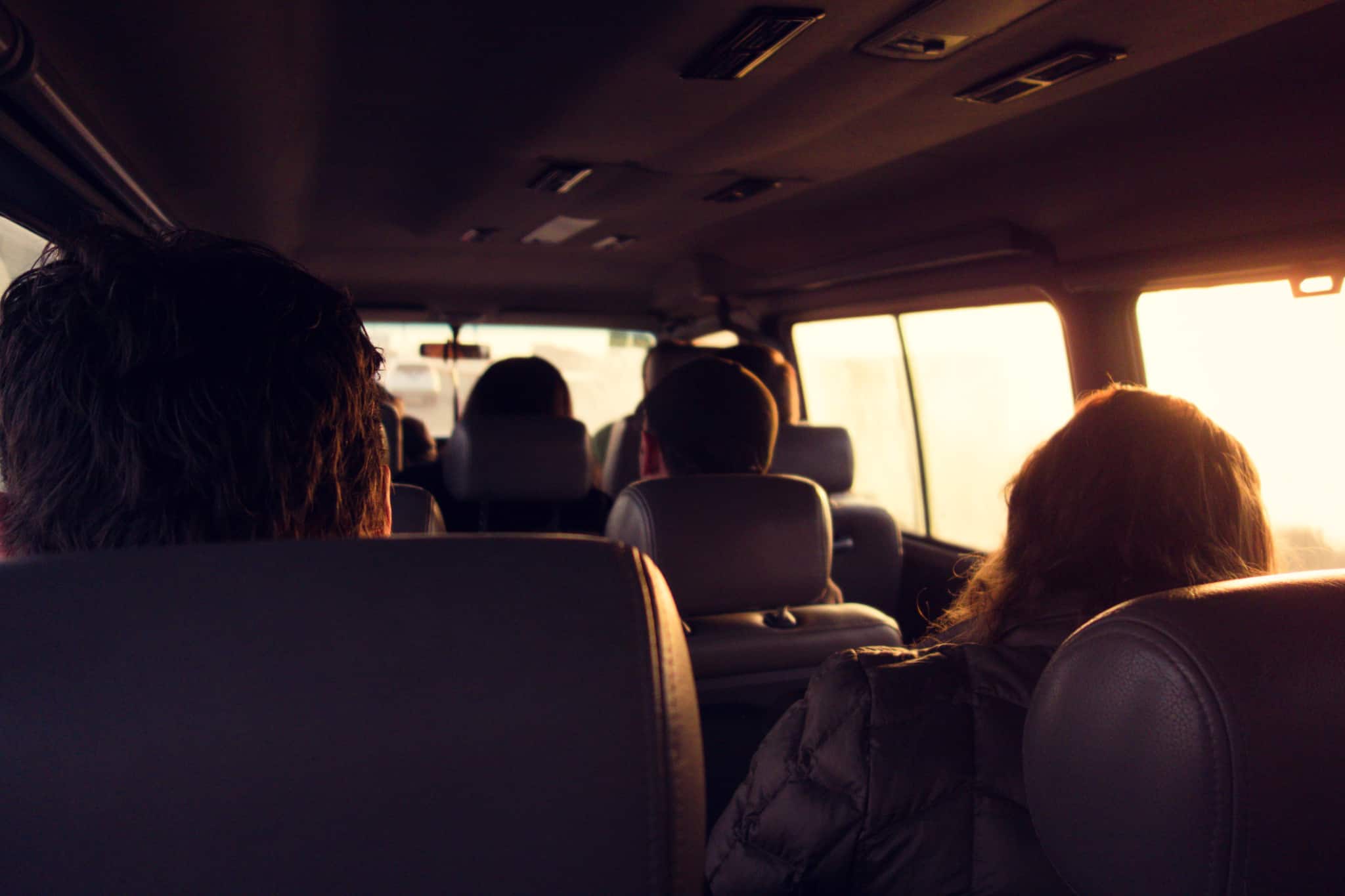 group of young people share a journey in a van to work
