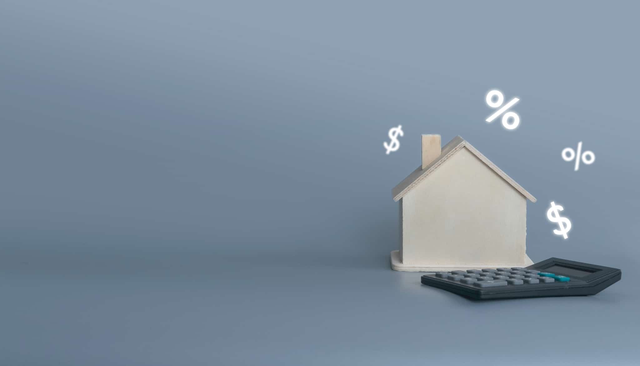 photographic production shows only a house surrounded by various financial symbols and accompanied by a calculator