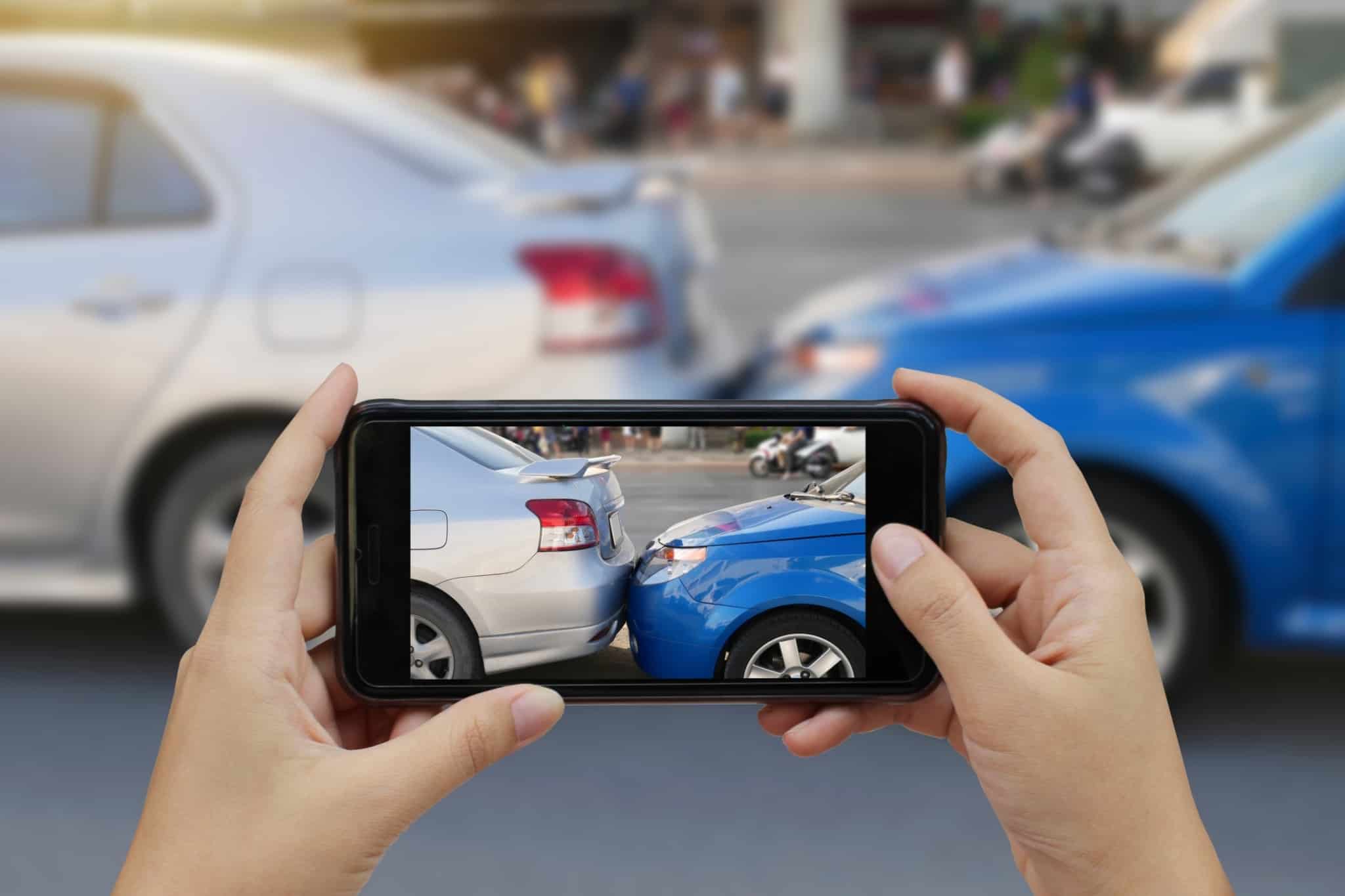 Person takes photo with cell phone of car accident