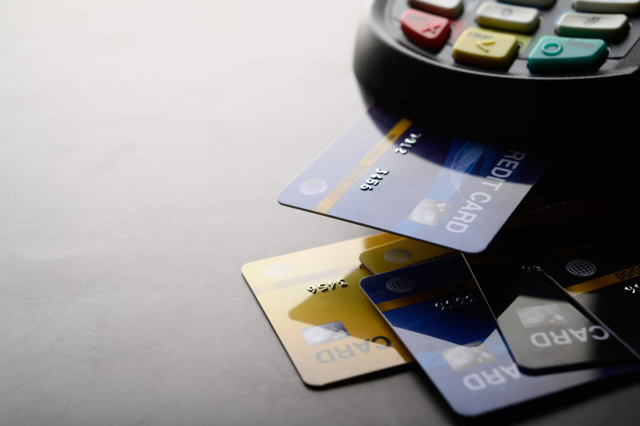 various types of credit cards which are inserted into a payment terminal placed on top of a table