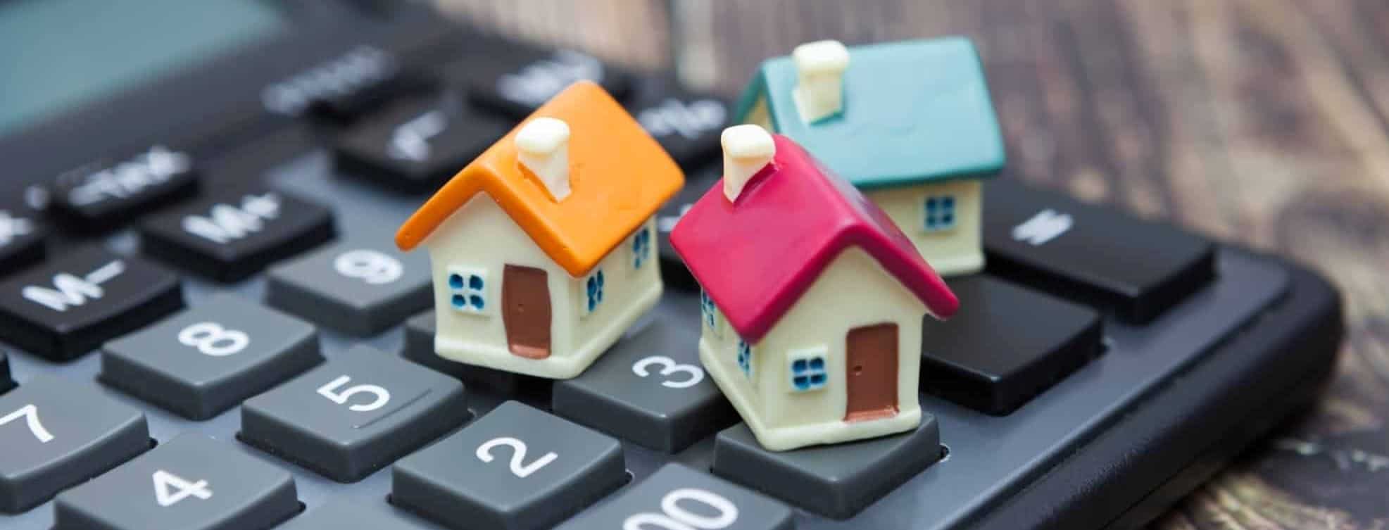miniature house figures on top of a calculator