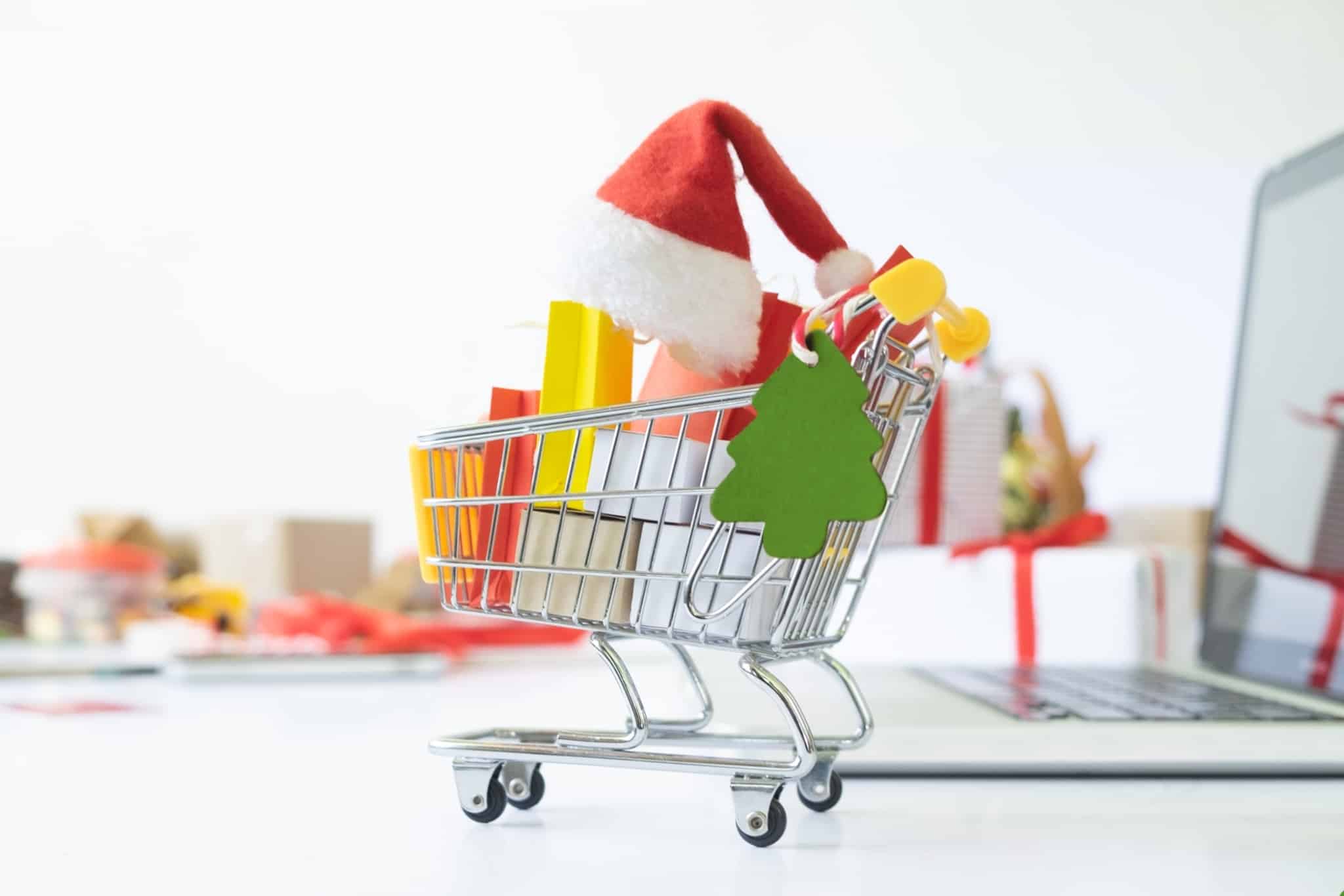 Christmas expenses illustrated with a photographic production that brought together symbols of the season inside a miniature supermarket trolley, placed on top of a laptop computer and Christmas packages