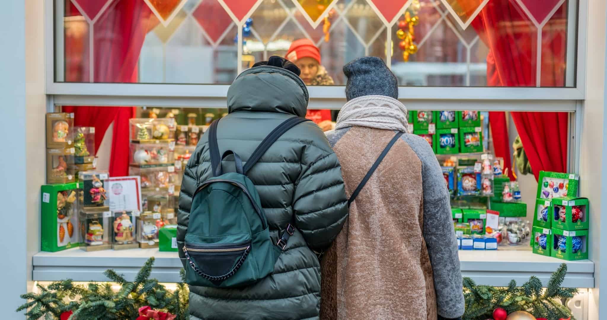 Couple in front of Christmas shop window buying presents