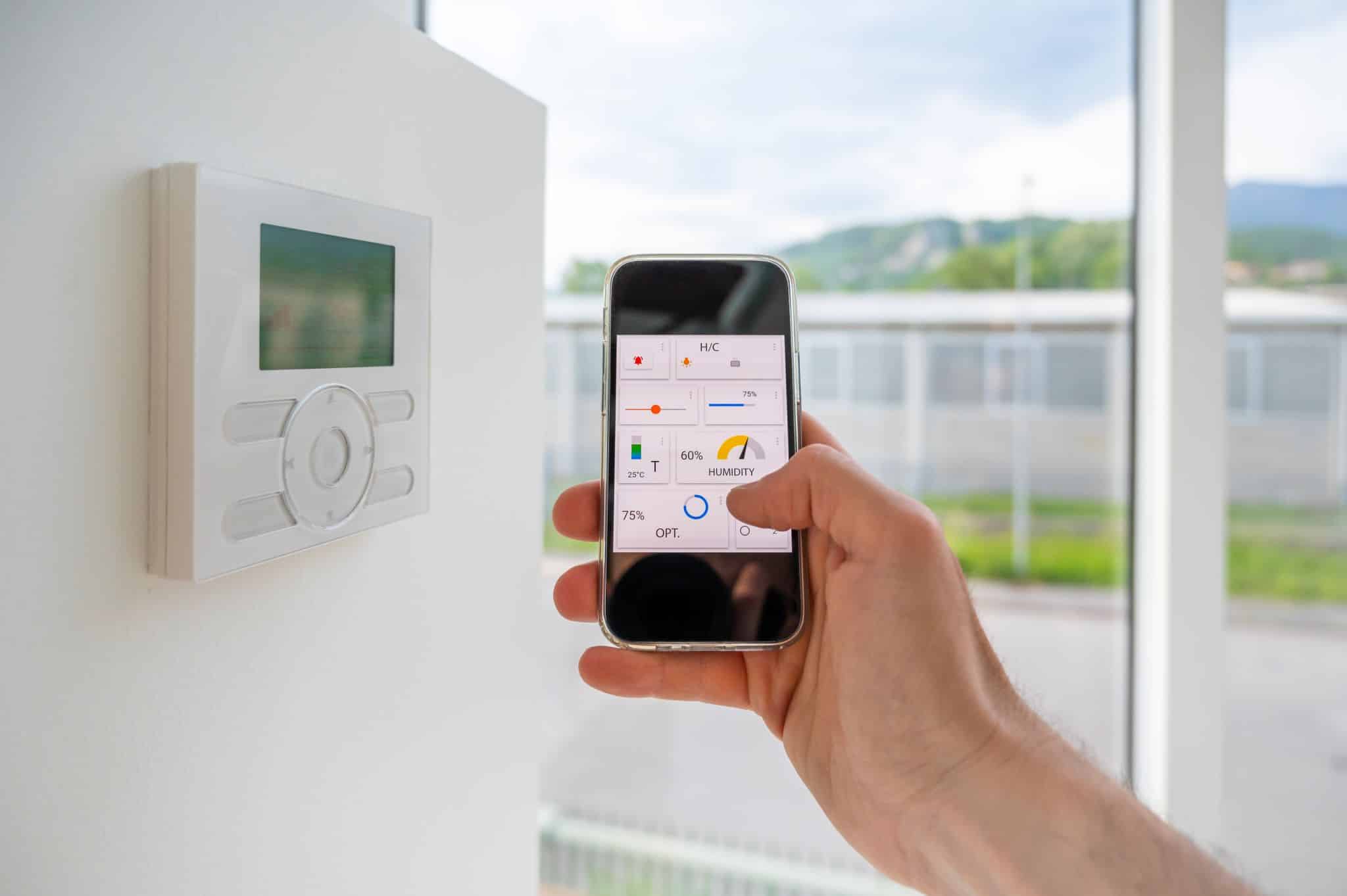 Hand picks up remote control evoking home automation in smart home