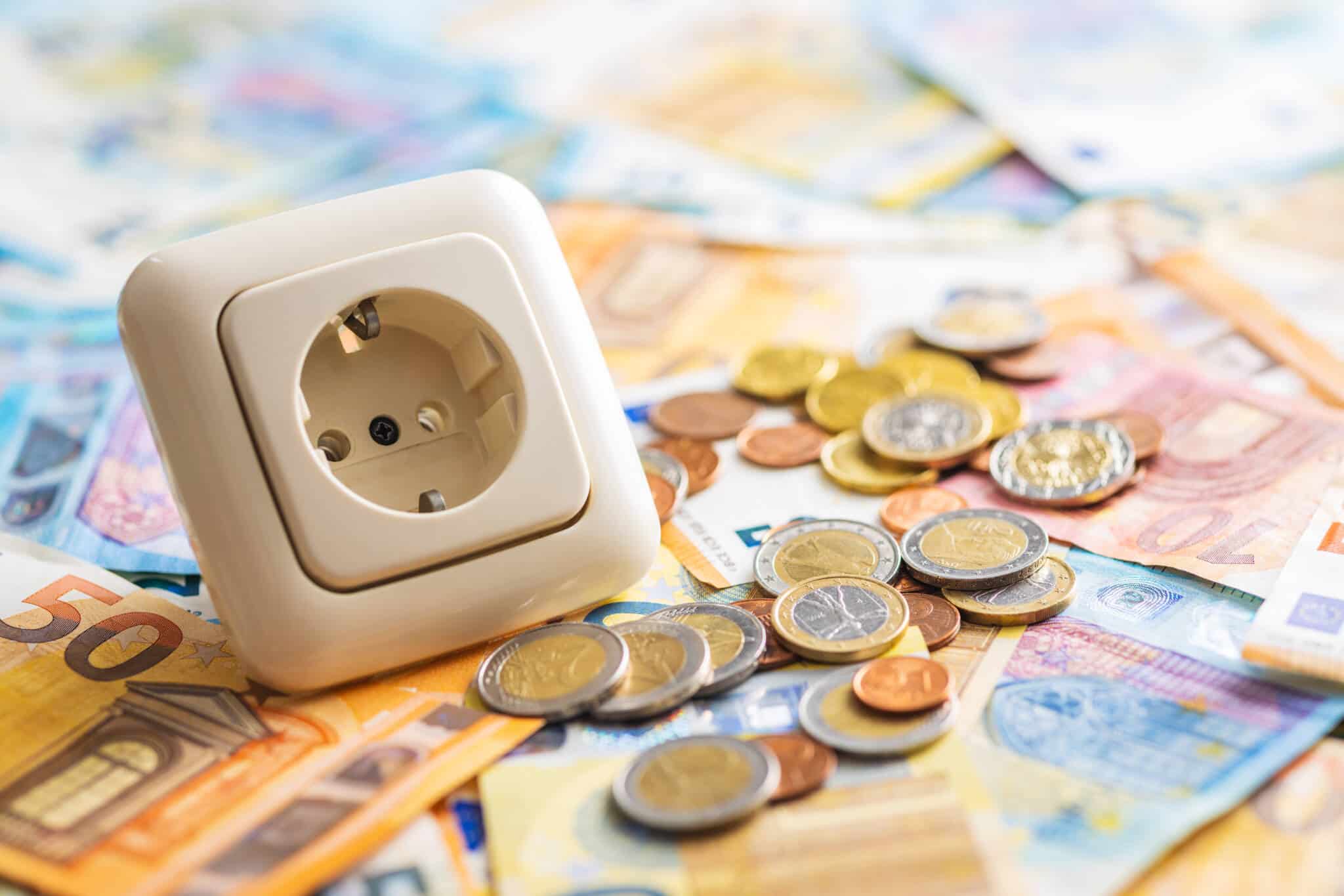 on top of a bunch of assorted Euro bills is an electrical plug illustrating more expensive electricity as of January
